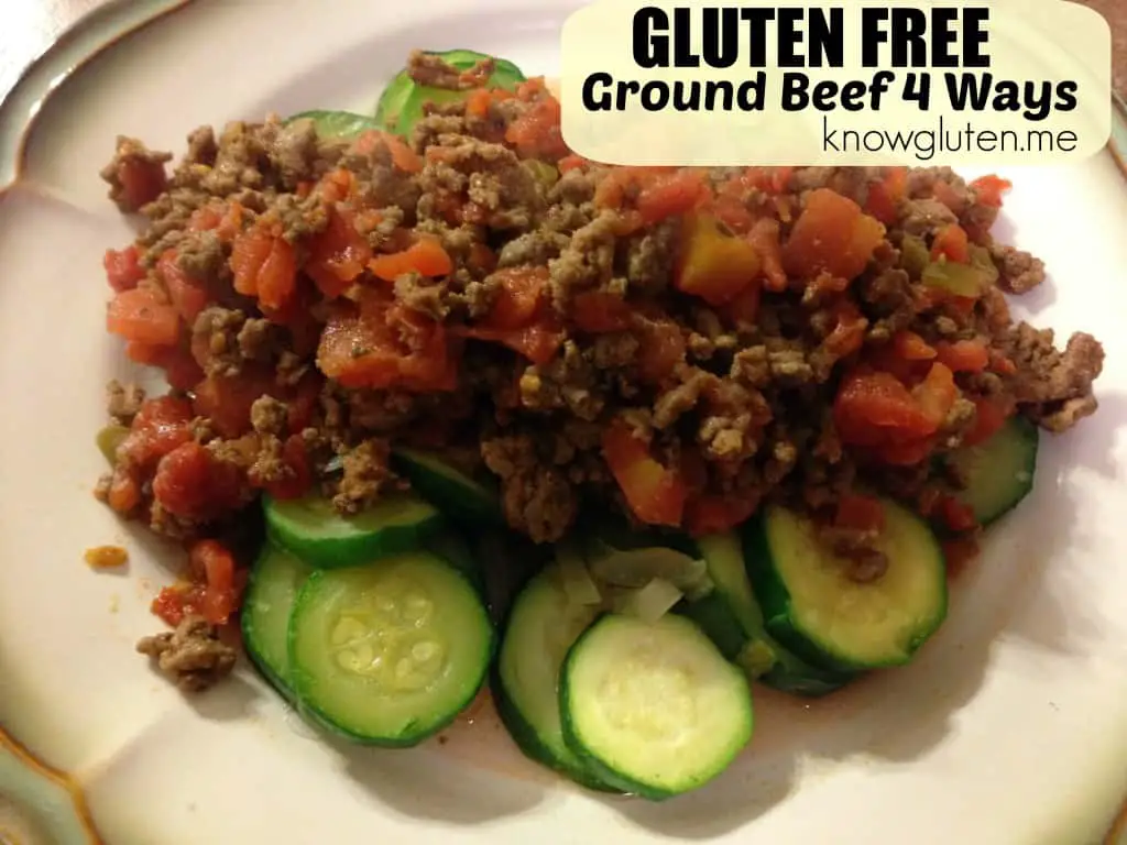 Ground beef with tomatoes on top of a bed of sliced zucchini.