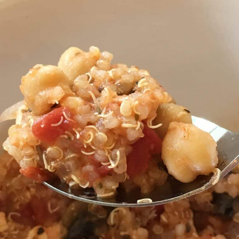 a bite of gluten free vegan quinoa casserole on a spoon. The image shows ingredient details.