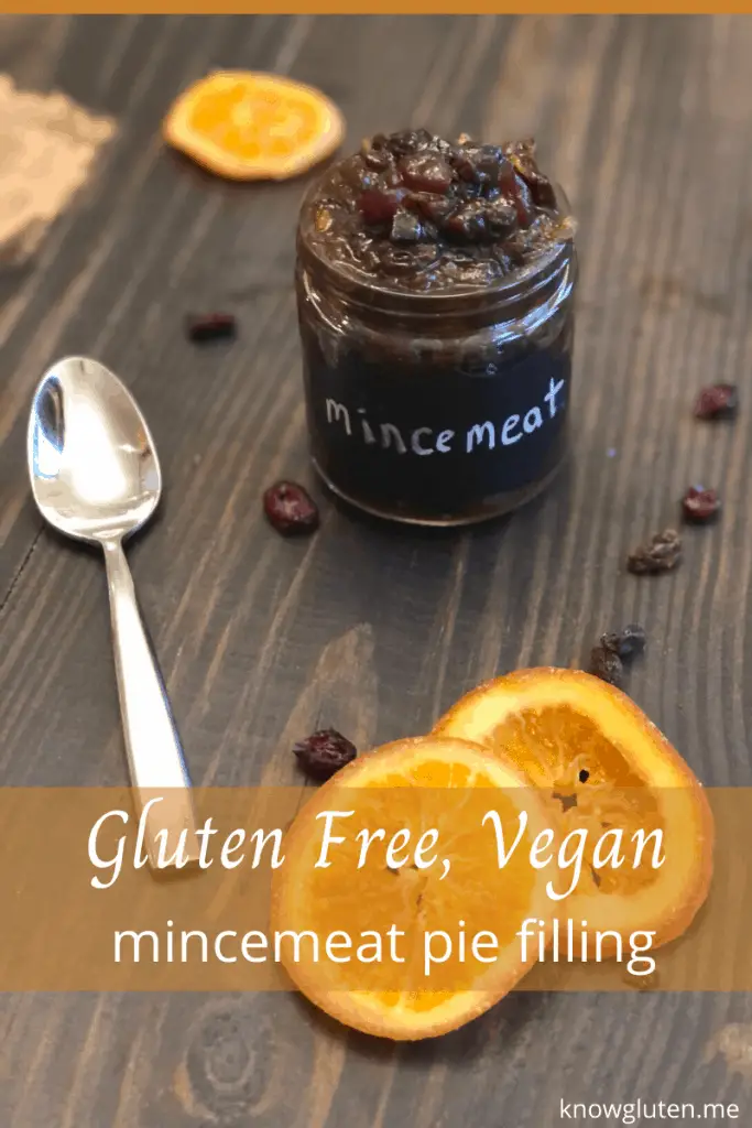 easy gluten free vegan mincemeat pie filling from knowgluten.me in a small jar on  a table with candied orange slices and raisins, with text in an orange banner