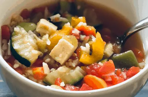 gluten free, vegan vegetable rice soup in a bowl on a wood table